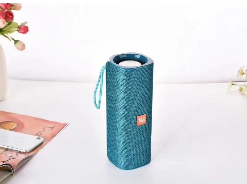 Cloth wireless Bluetooth speaker in multiple colours showing front grill and control buttons.