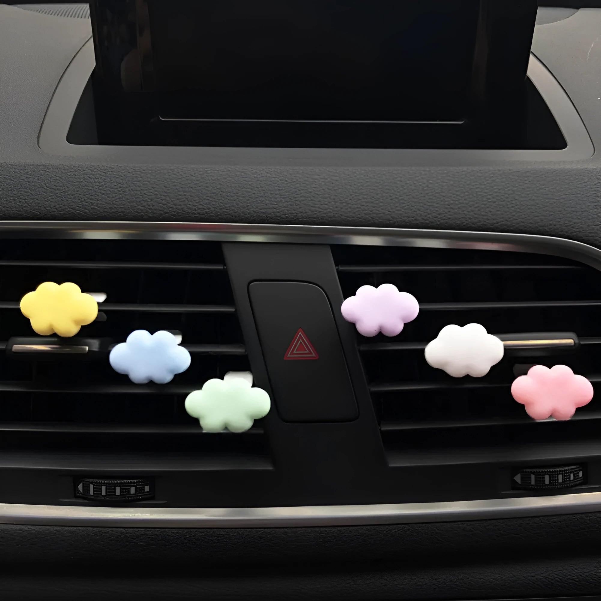 Resin cartoon-style car fragrance clip attached to a vehicle air vent.