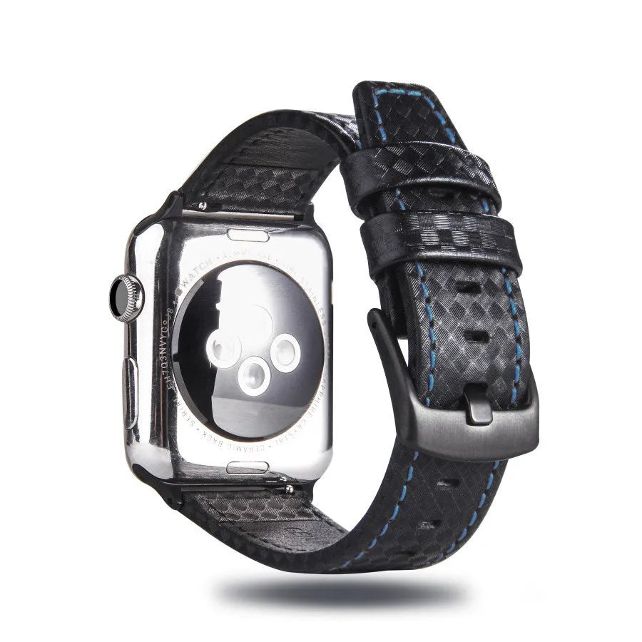 Leather and carbon fibre Apple Watch strap with red stitching next to a black PC case with carbon fibre pattern.