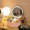 Round pink PU leather makeup bag open showing illuminated mirror and internal partitions.