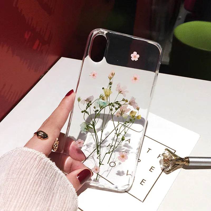 Clear iPhone case with dried pink Qianliyao flowers preserved in epoxy resin on transparent TPU back