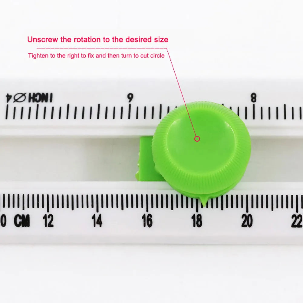 Green plastic round rotary paper cutter on a desk next to an A3 sheet of paper.