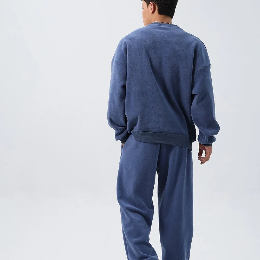 Men's black polar fleece sports suit set with long sleeve coat and loose trousers on a hanger.