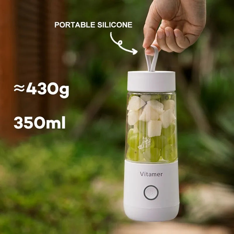 White portable USB rechargeable blender bottle with silicone lift ring, shown next to its charging cable.