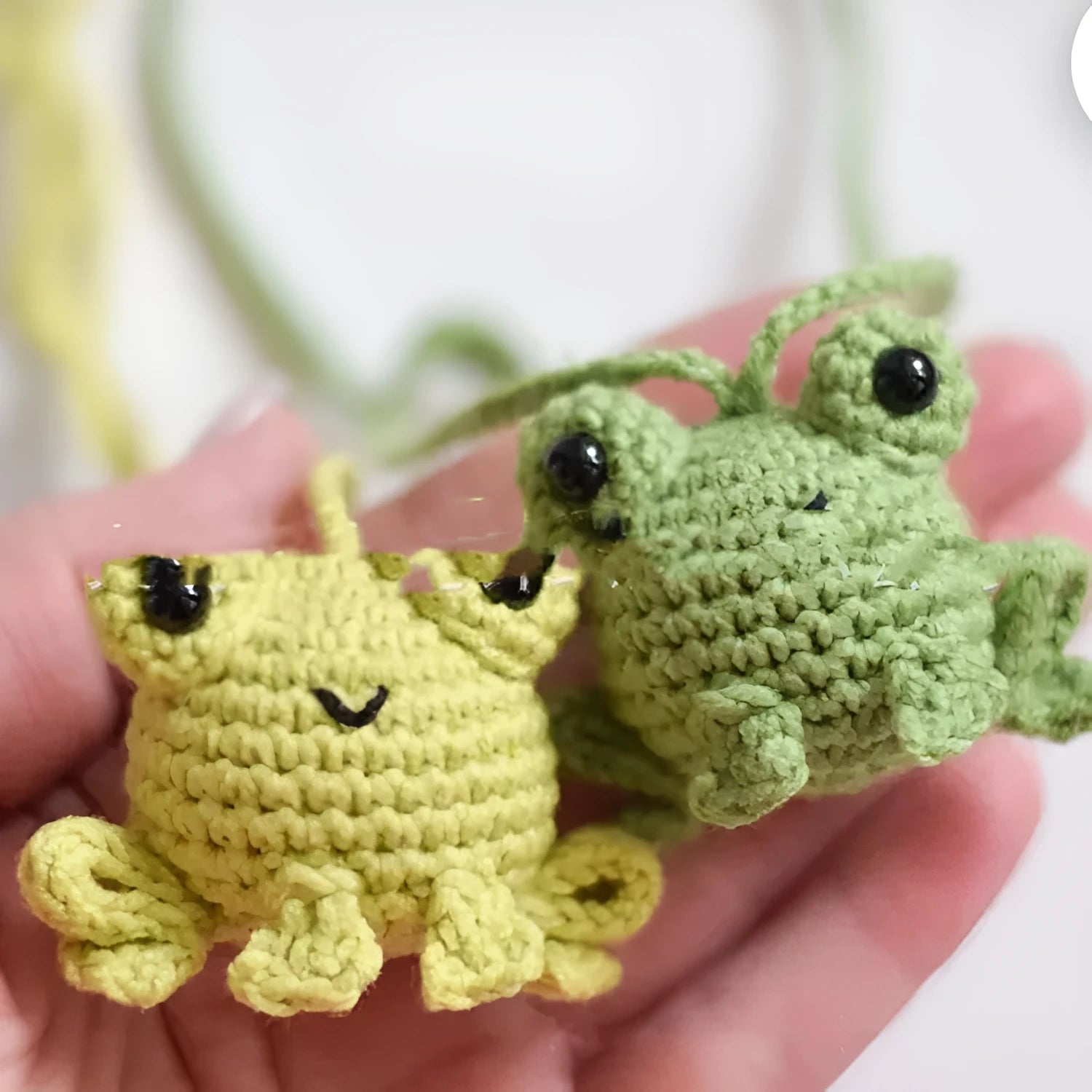 Handmade green plush frog car pendant hanging, showing woven cord and cartoon style.