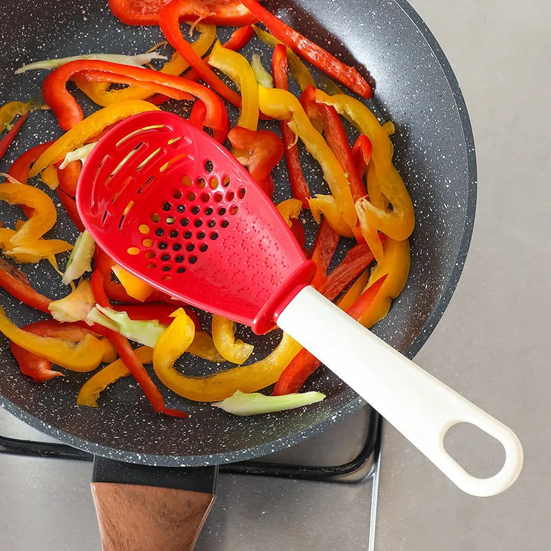 Red plastic multifunctional slotted spoon with half-enclosed head and convex serrations for cooking tasks