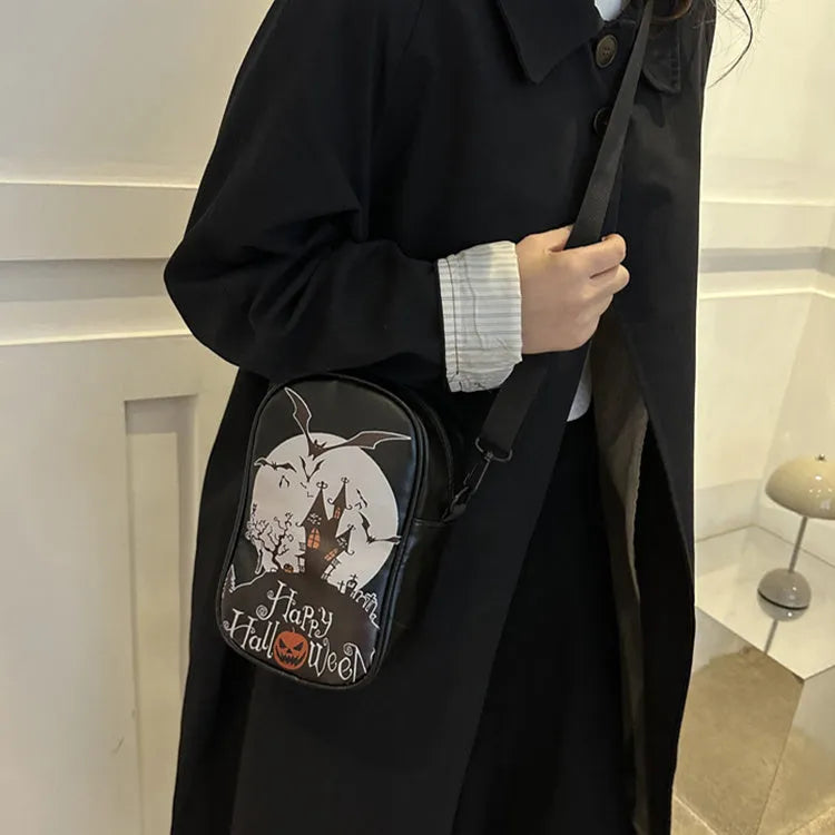 Black Halloween graffiti crossbody bag with cartoon pumpkin, ghost, and bat print, shown with adjustable strap.
