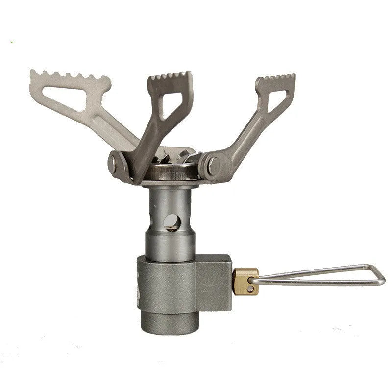 Compact portable propane camping stove with one-piece pressed steel furnace, black finish, and extended legs on a rocky surface.