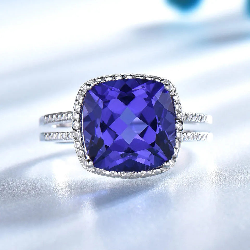 A blue tanzanite stone set in a sterling silver women's ring on a white background.