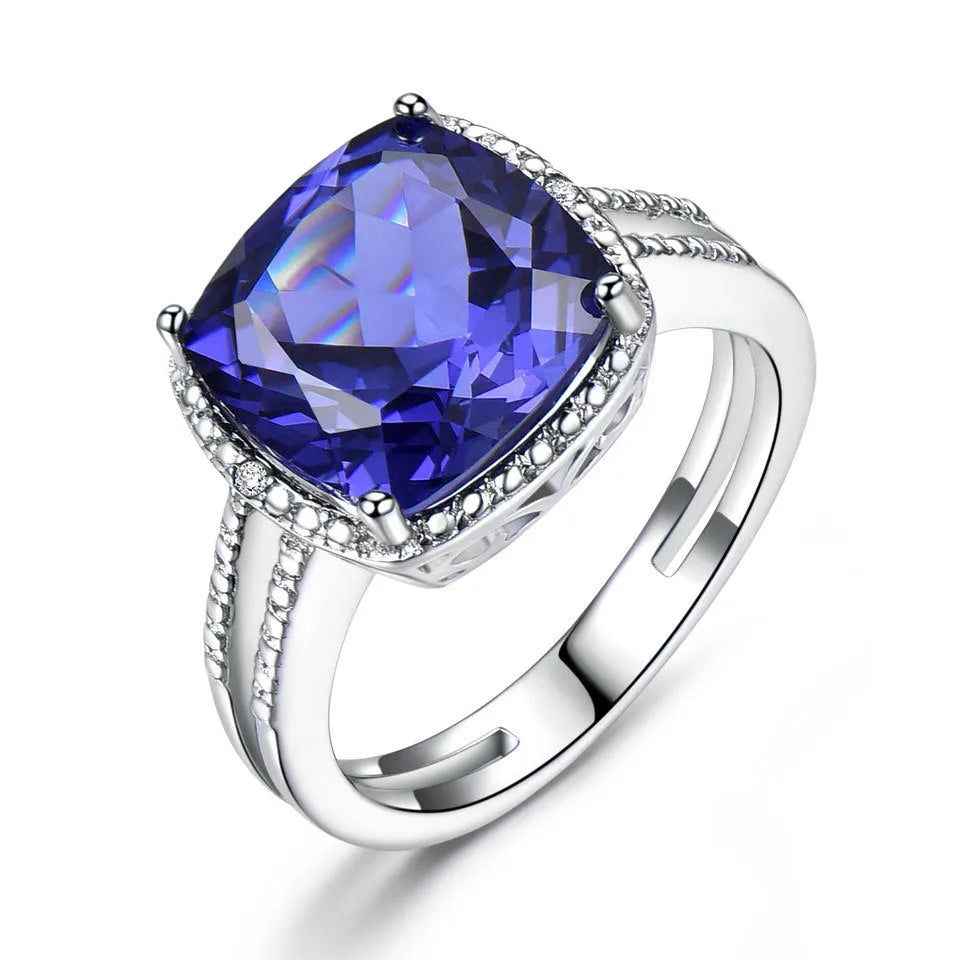 A blue tanzanite stone set in a sterling silver women's ring on a white background.