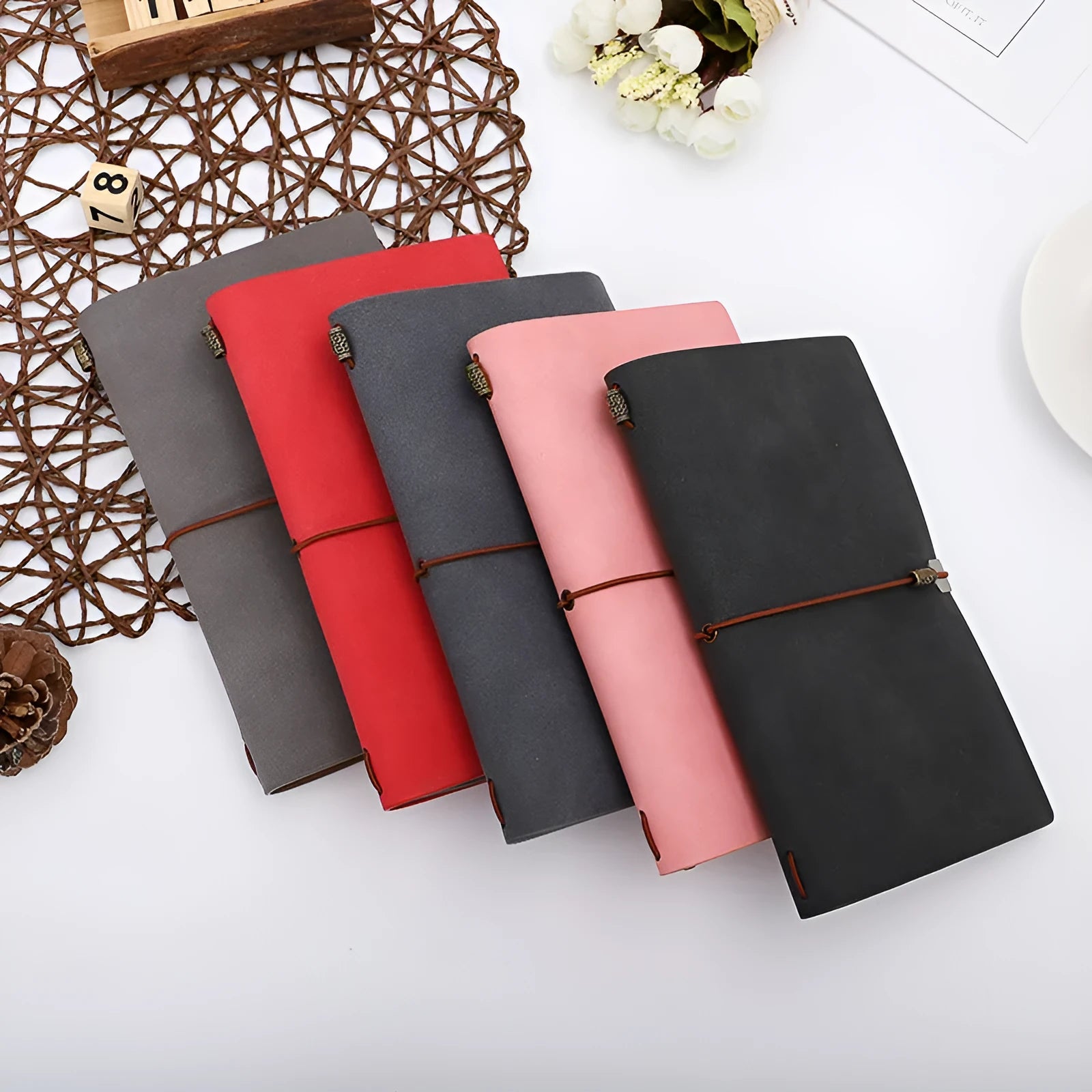 A6 diary with cowhide rope binding in grey, pink, or red colour options lying open