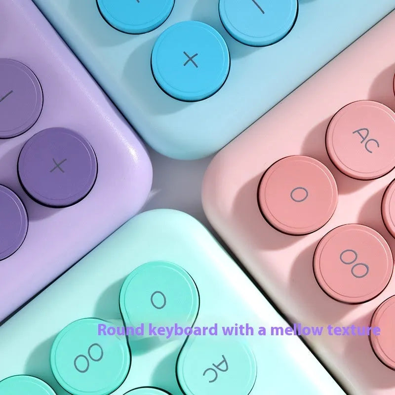 Gradient colour desktop calculator in violet, pink, blue, or green on a desk.