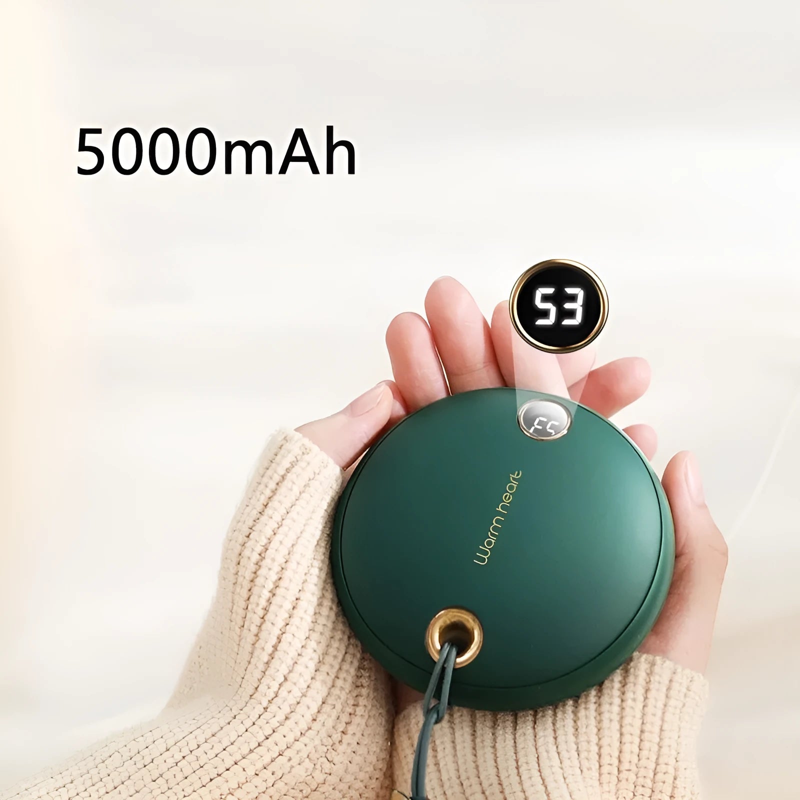 Green 5000mAh power bank hand warmer with digital display shown next to its charging cable.