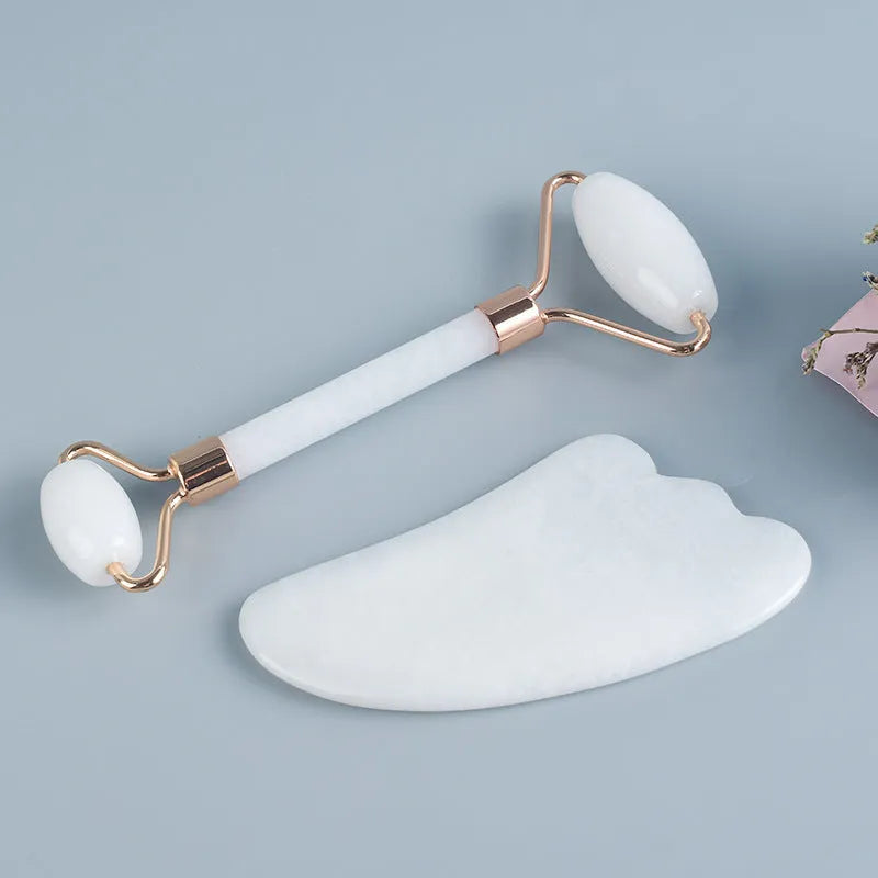 White jade double-headed facial roller and gua sha scraping tool set on a storage board.