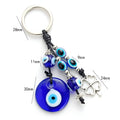 Blue metal eye of evil keychain 4cm pendant with plant-inspired design on grey background