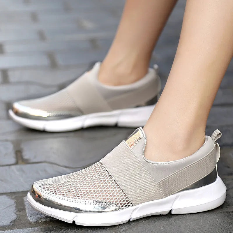 Blue women's low-top casual sneakers with mesh interior on a hard floor.