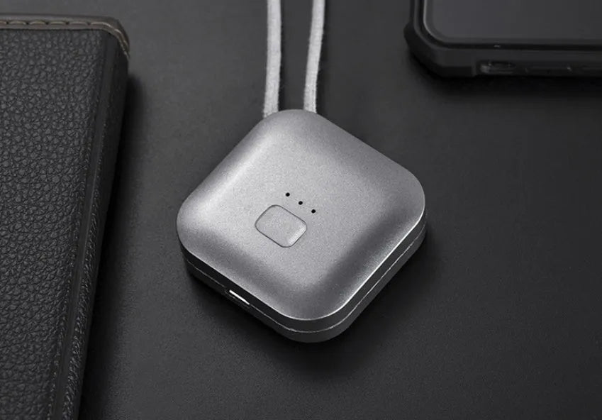 Mini USB portable air purifier necklace in pink, showing compact size and wearable design.