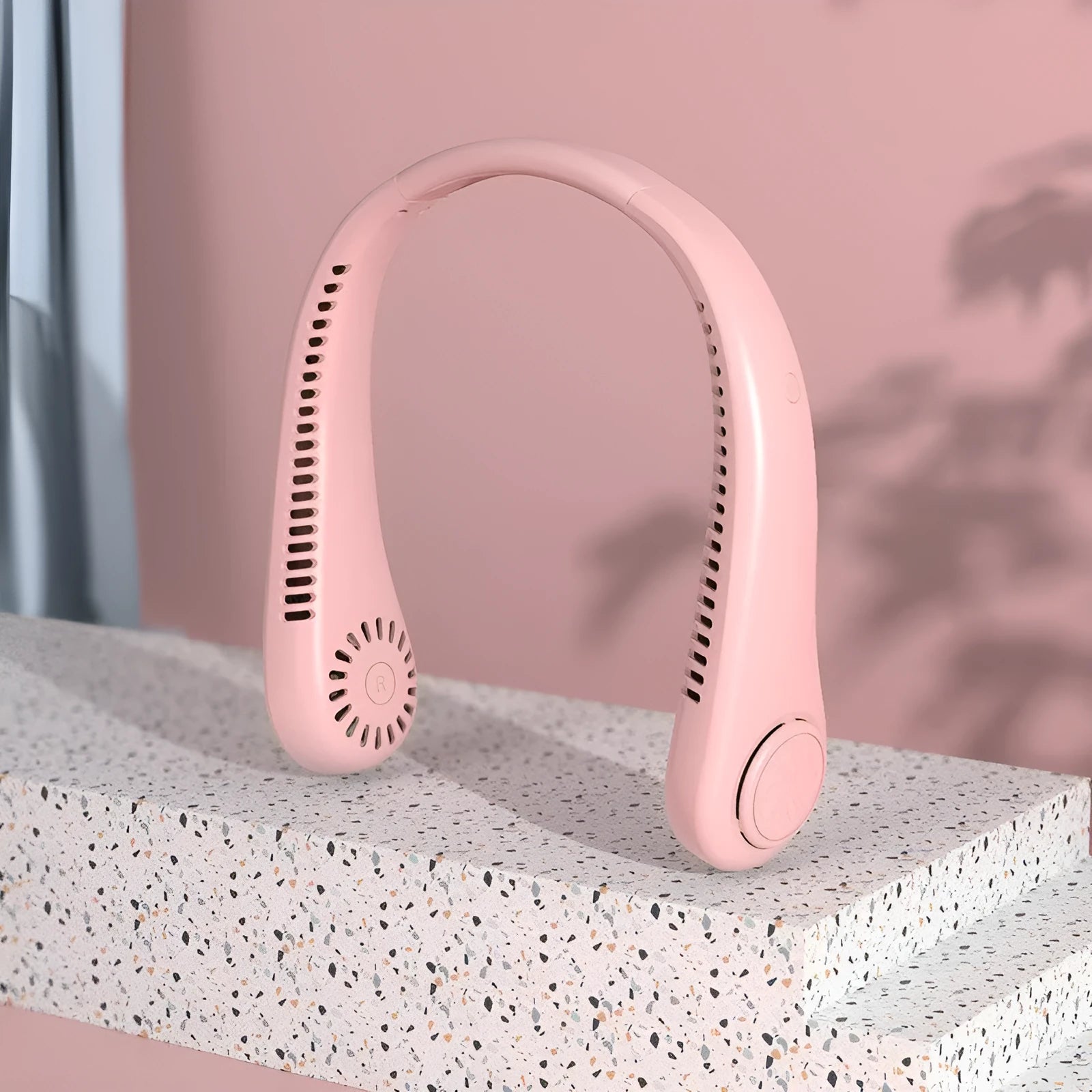 Pink USB rechargeable bladeless neck fan with flexible band, showing adjustable speed buttons.
