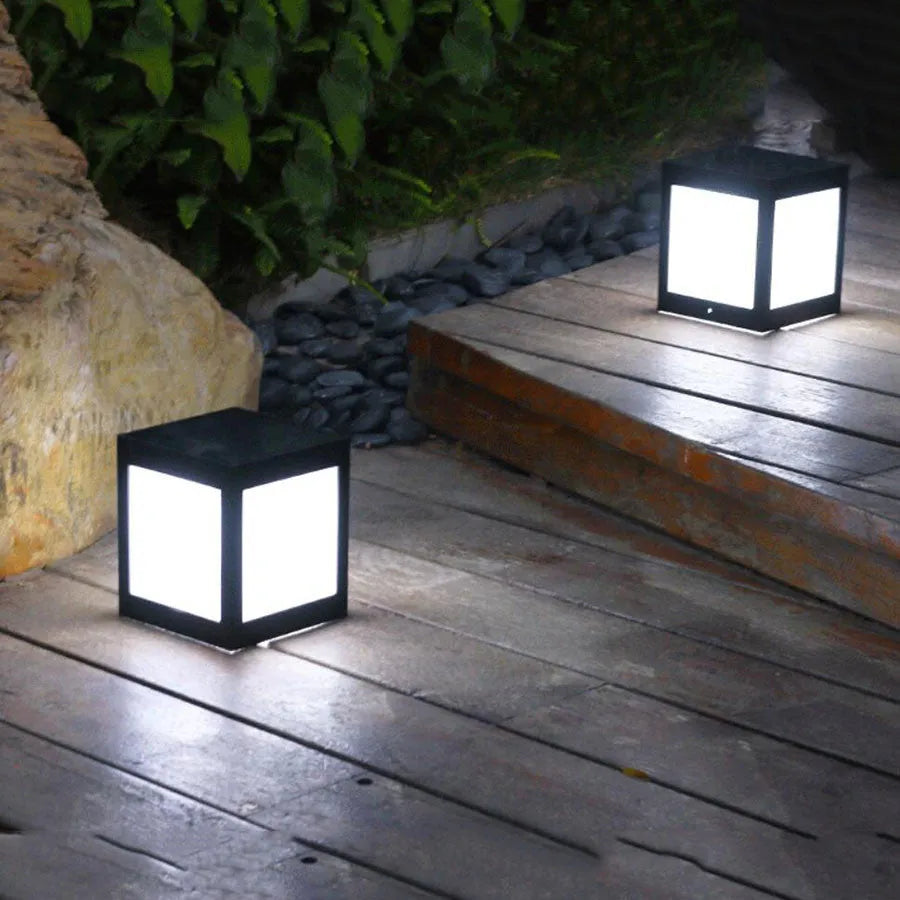 Set of solar-powered LED garden lights in various styles illuminating an outdoor patio at dusk.