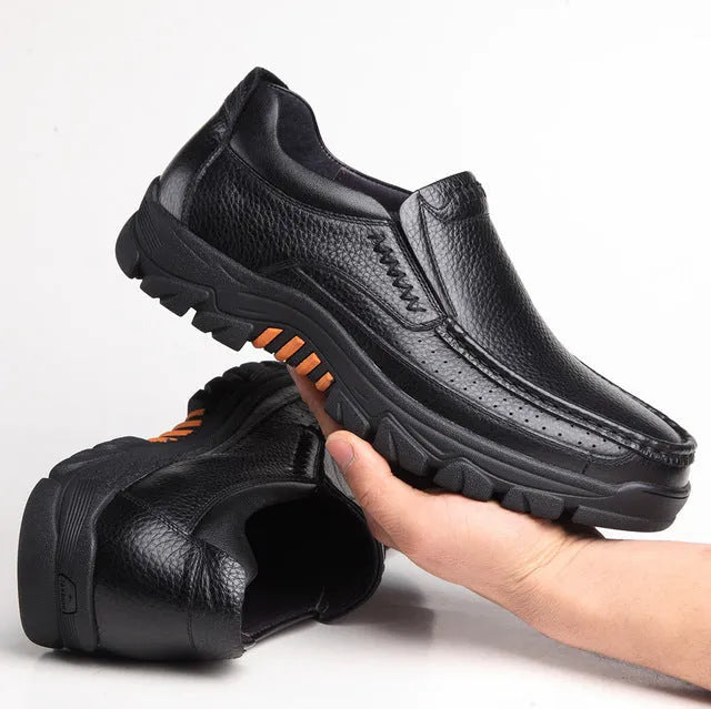 A pair of men's black slip-on business casual shoes made from cowhide leather with a rubber sole.