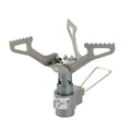 Compact portable propane camping stove with one-piece pressed steel furnace, black finish, and extended legs on a rocky surface.