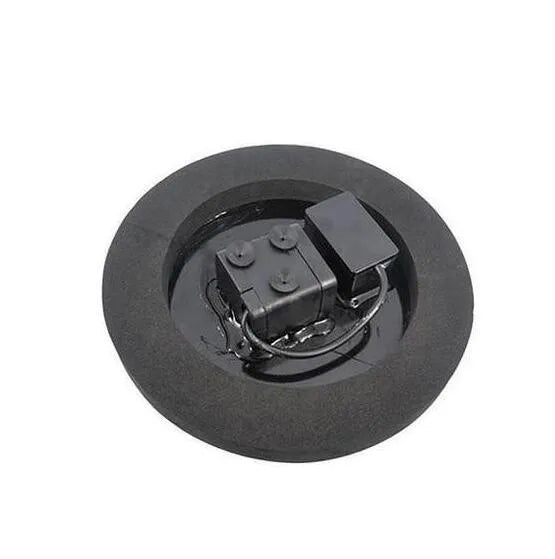 Black solar fountain pump with four spray nozzles on a green grass background next to a birdbath.