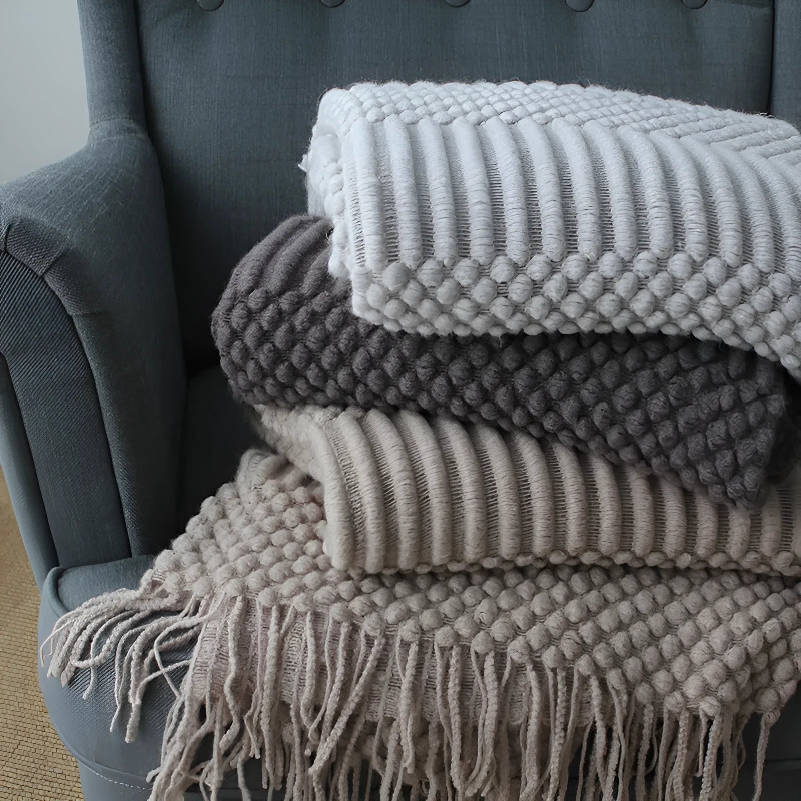 Small light grey polyester nap blanket laid flat showing its size.