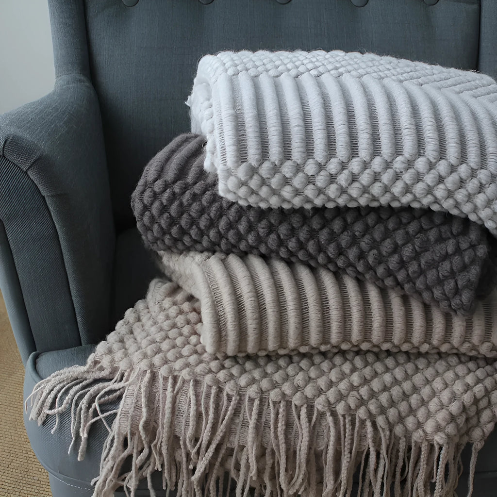 Small rectangular polyester nap blanket in dark grey, khaki, and light grey colours, measuring 127 by 170 cm.