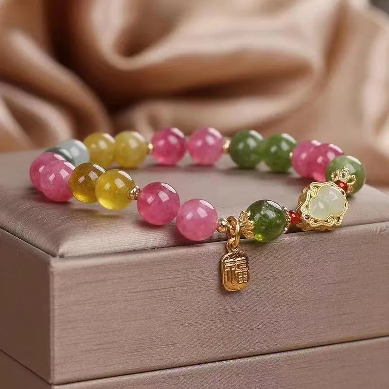 Close-up of a women's gourd blessing card bracelet with colourful tourmaline stones and electroplated finish.