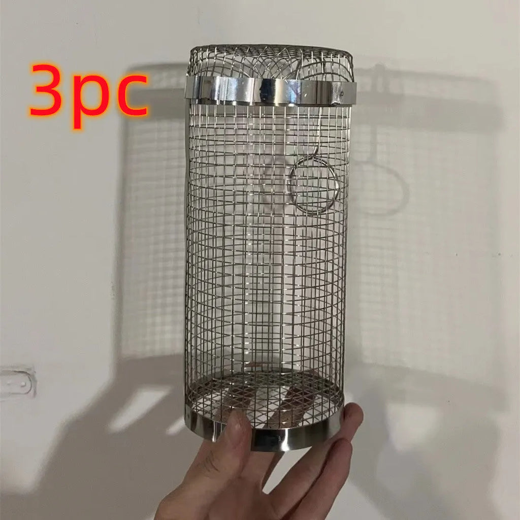 A cylindrical iron wire mesh rolling barbecue basket with a metal hook for handling.