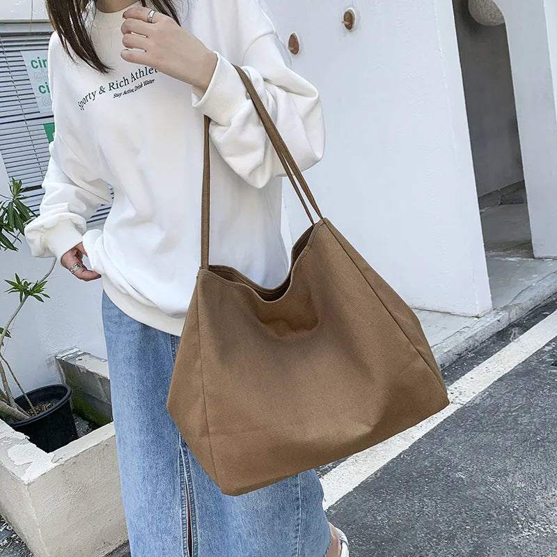Women's solid colour canvas handbag showing horizontal square shape with double shoulder straps