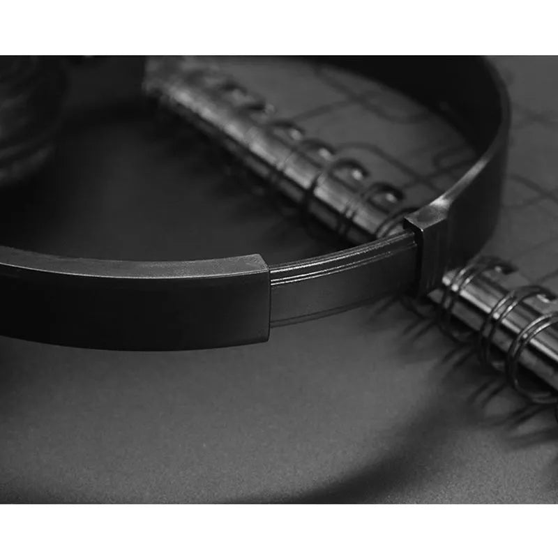 Black folding over-ear wired headphones with adjustable headband and 3.5mm plug on a coiled TPE cable.