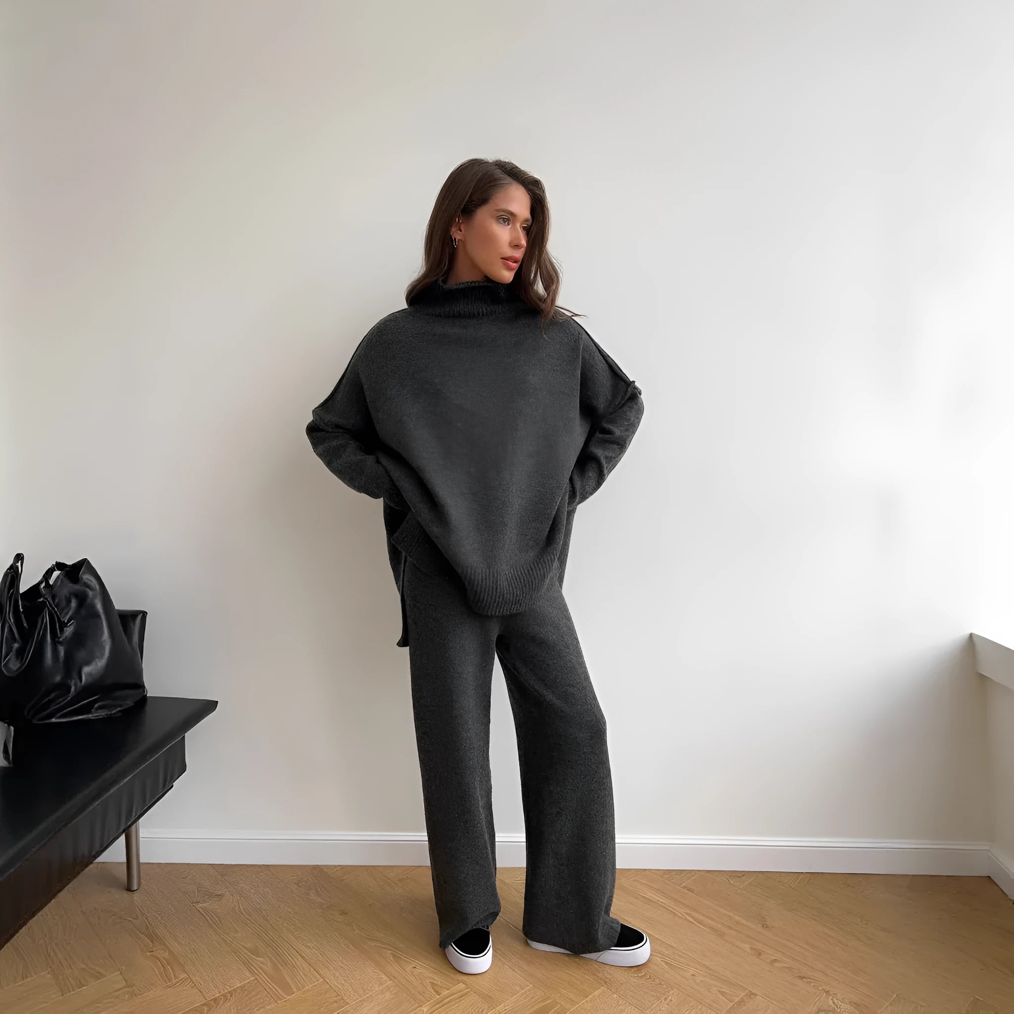 Women's dark grey acrylic sweater with side slits and matching full-length trousers laid flat.