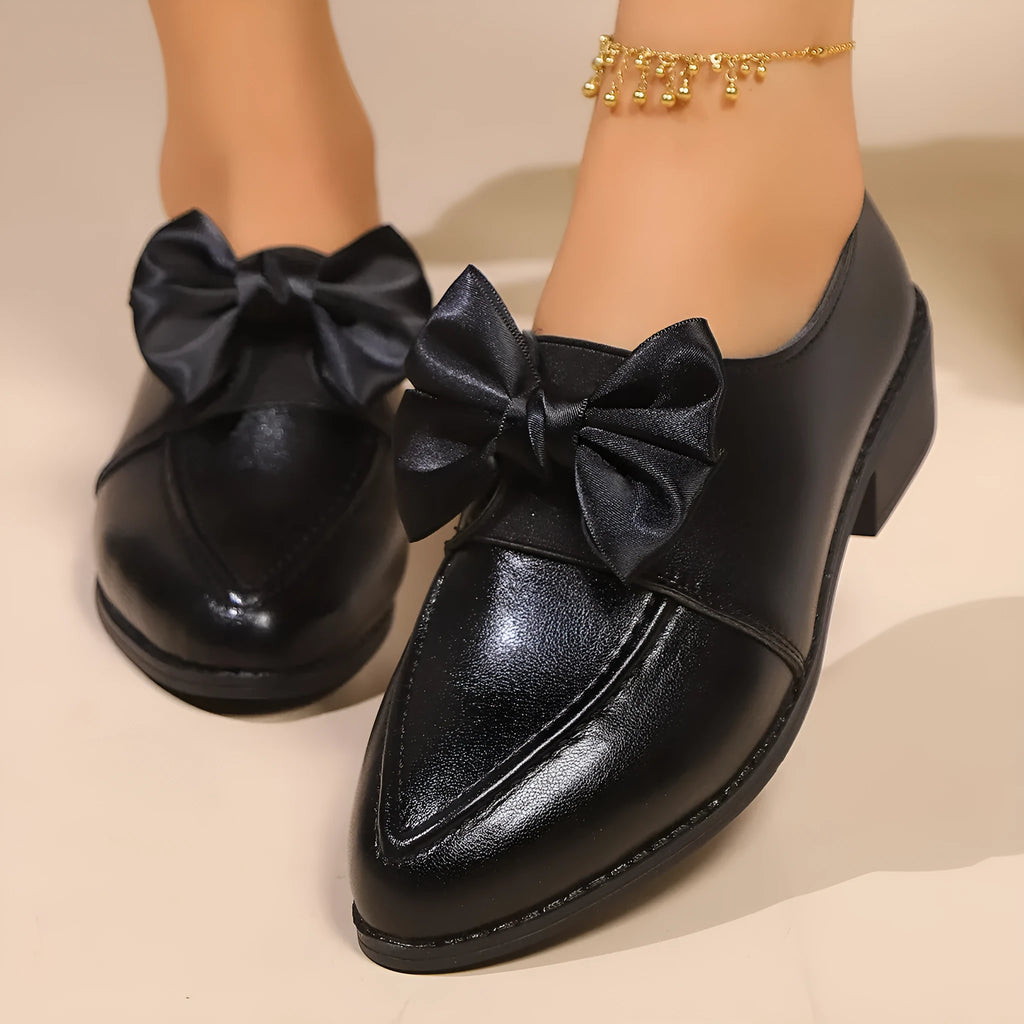 Women's pointed toe shoes with a choice of large buckle bow or small bowknot detail on a PU leather upper.