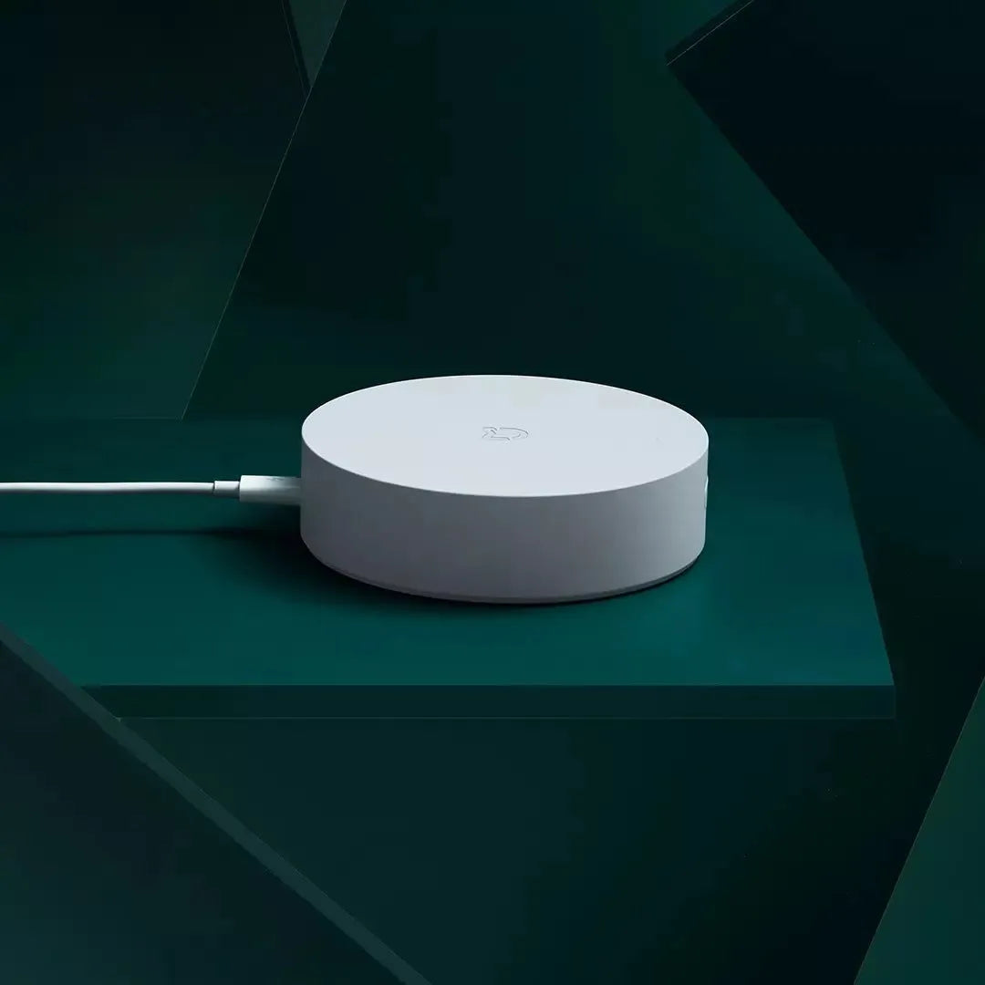 White circular intelligent multimode gateway for smart home remote control, 90mm diameter with UK plug.