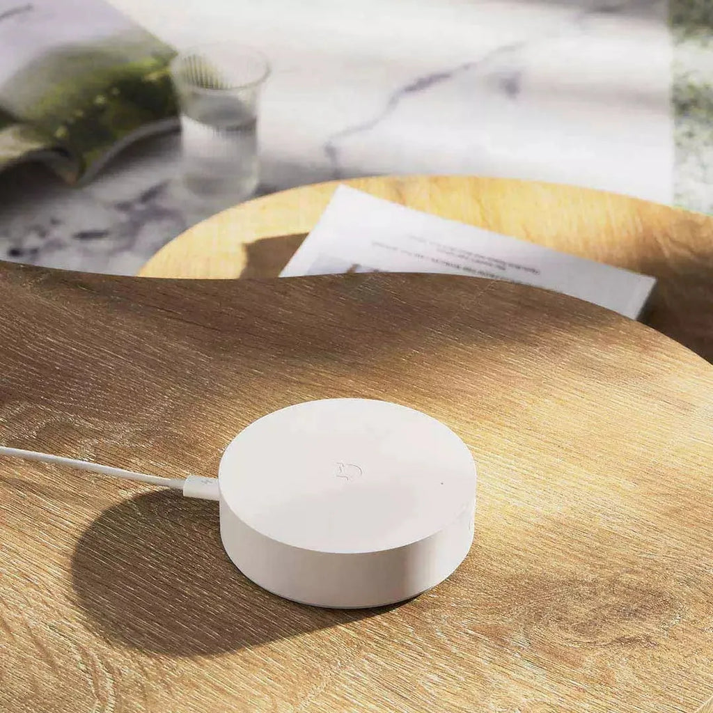 White circular intelligent multimode gateway for smart home remote control, 90mm diameter with UK plug.