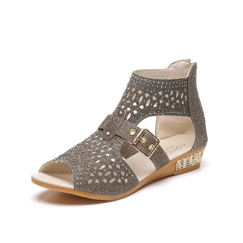 Women's beige rivet flat sandals with back zipper and low wedge heel on a white background.