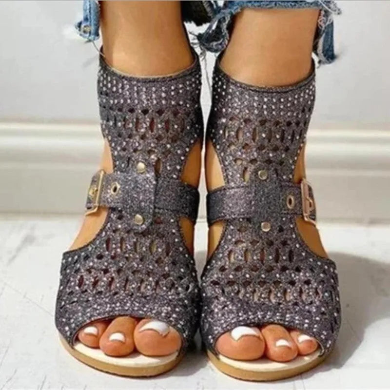 Women's beige rivet flat sandals with back zipper and low wedge heel on a white background.