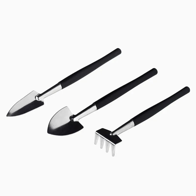Black plastic and metal mini garden tool set for succulents with kneeling cushion, showing shovel, tweezers, scissors, and watering bottle.
