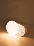 White Baseus rechargeable motion sensor night light on a bedside table
