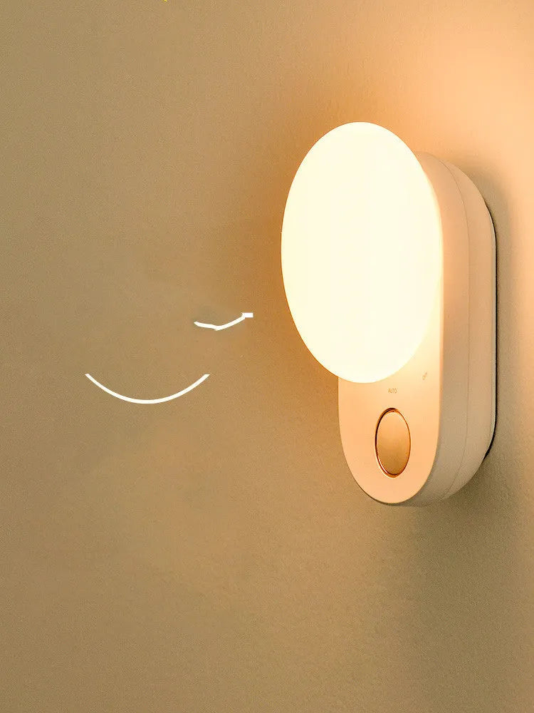 White Baseus rechargeable motion sensor night light on a bedside table