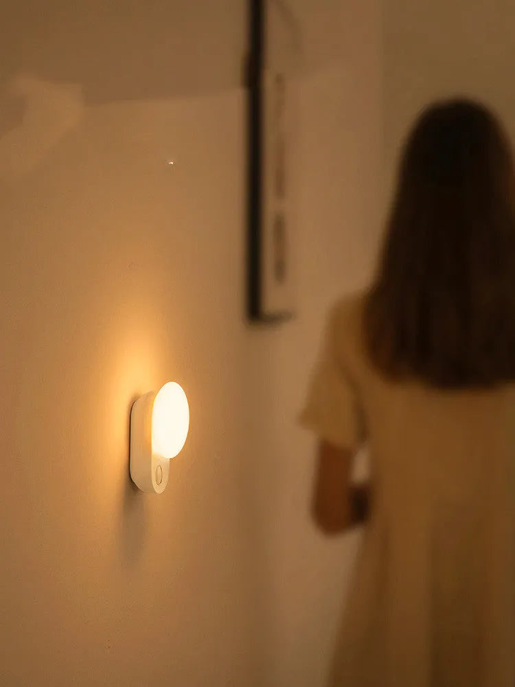 White Baseus rechargeable motion sensor night light on a bedside table