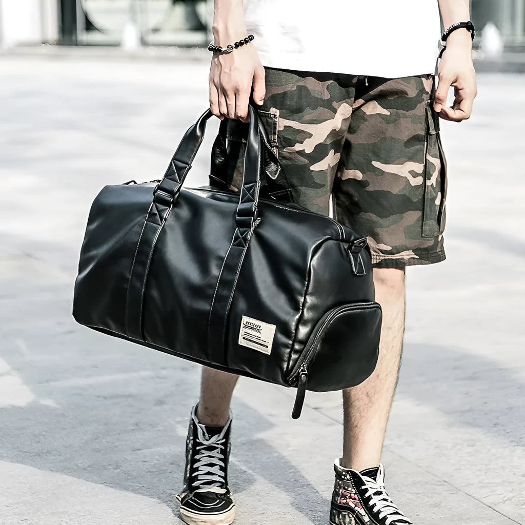 Black PU leather sports training bag with external handles, shoulder strap, and multiple internal organisational pockets.