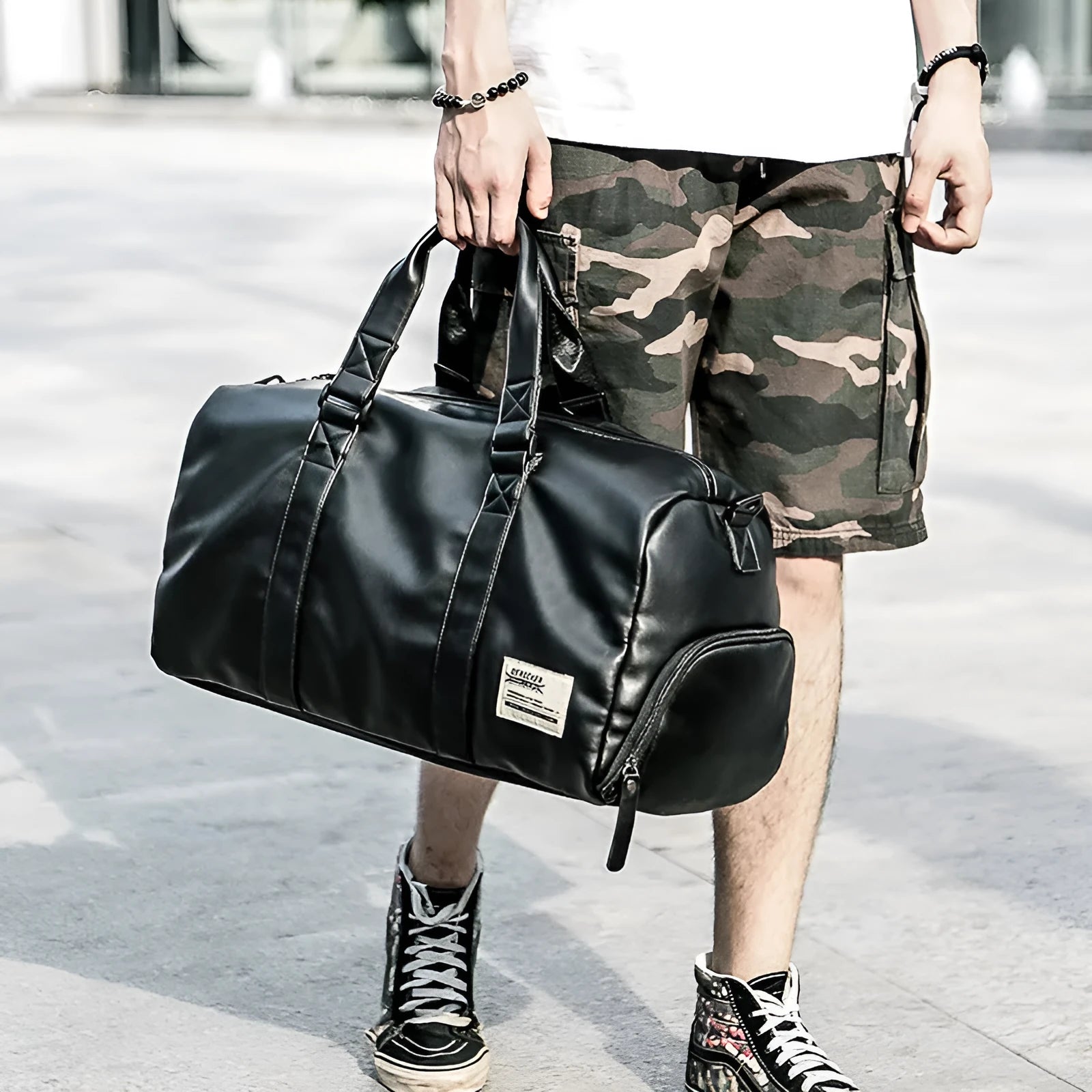 Black PU leather sports training bag with external handles, shoulder strap, and multiple internal organisational pockets.