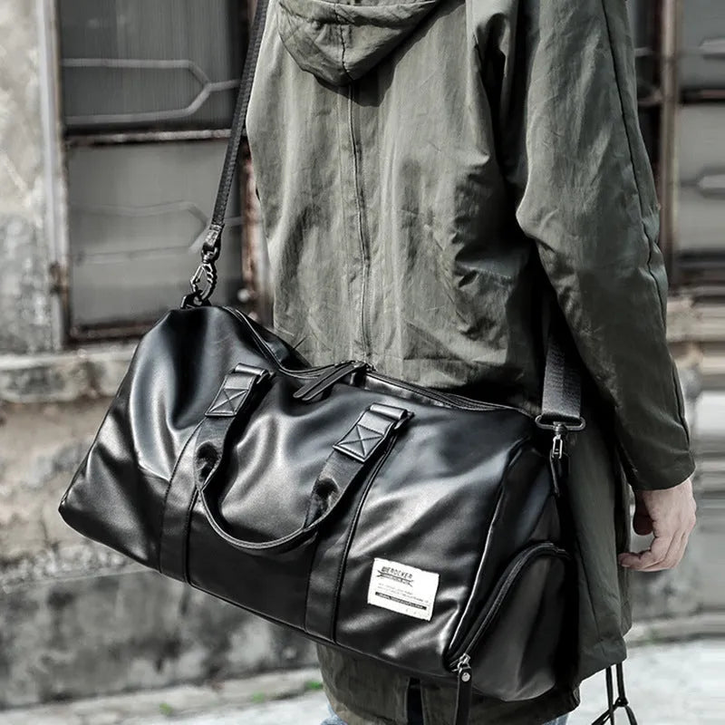 Black PU leather sports training bag with external handles, shoulder strap, and multiple internal organisational pockets.