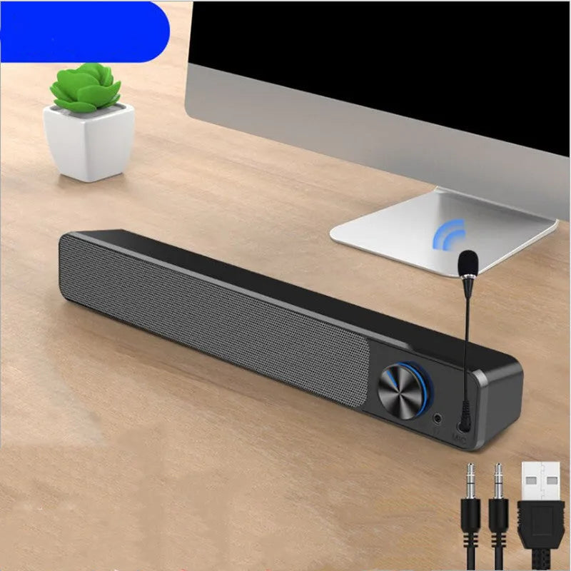 Black and white USB-powered desktop computer speakers with 2.0 stereo sound on a wooden desk.
