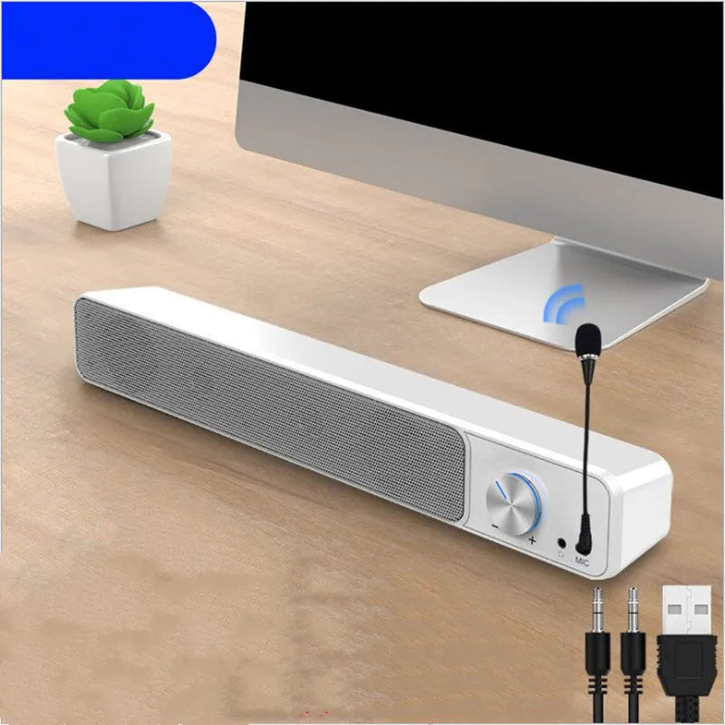 Black and white USB-powered desktop computer speakers with 2.0 stereo sound on a wooden desk.