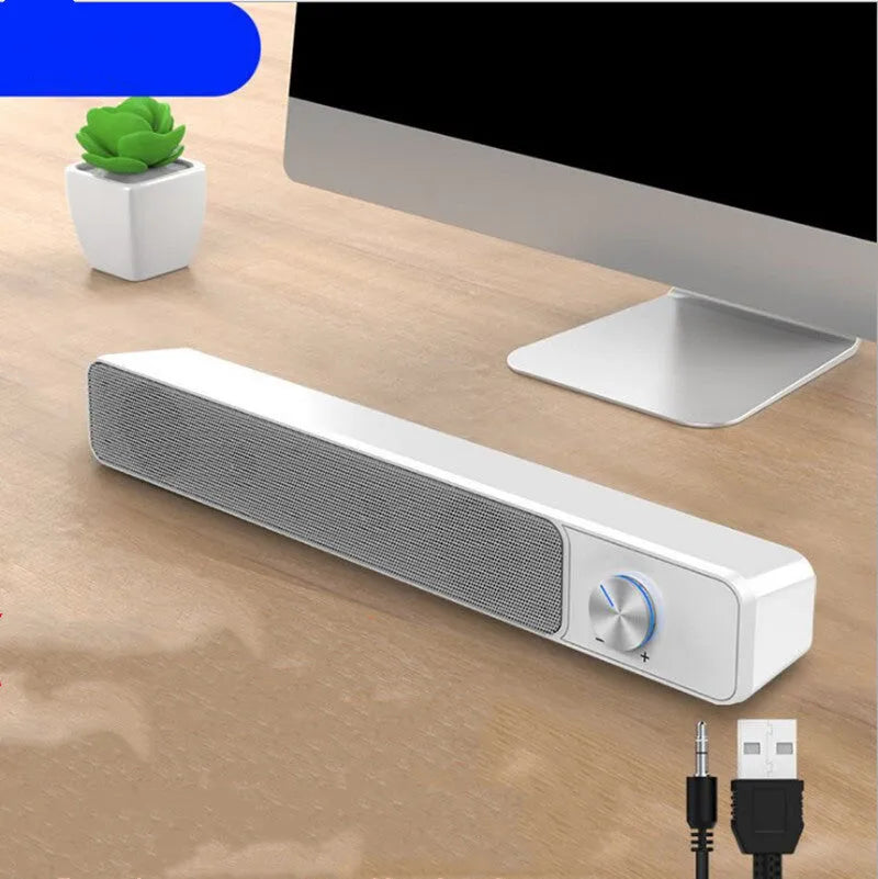 Black and white USB-powered desktop computer speakers with 2.0 stereo sound on a wooden desk.
