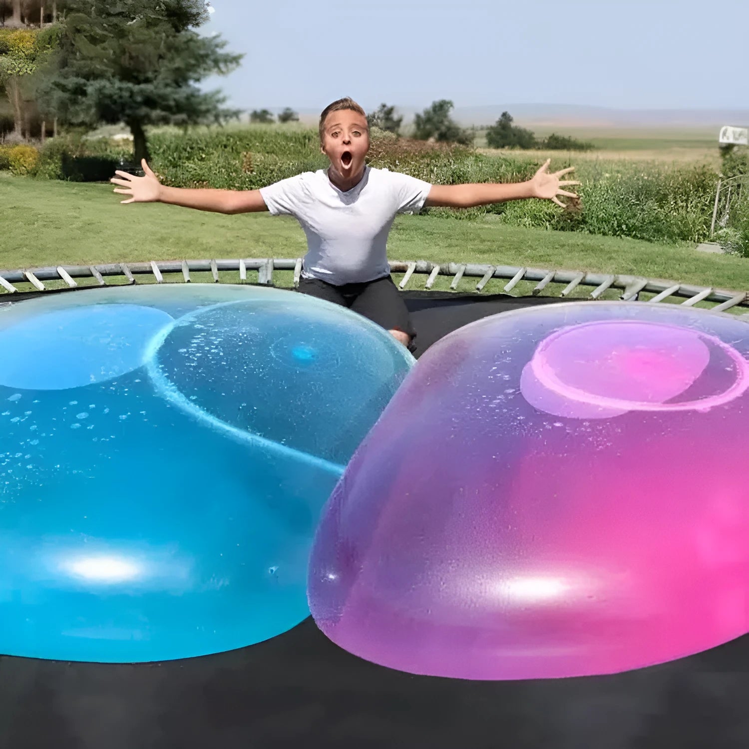 Assortment of inflated pink, yellow, blue and green TPR bouncy balls in different sizes on a plain background.