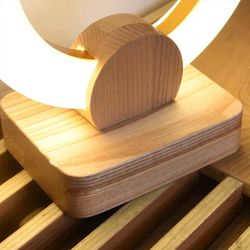 Nordic style wooden circular chandelier with acrylic shade in a living room setting.